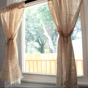 Natural colored curtains in sunny window with twine tiebacks. Jacqueline's Textiles handwoven fabric in NOVA.
