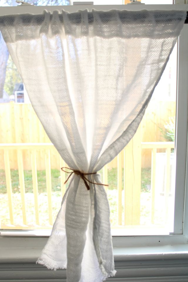 One curtain tied with twine in a sunny window. Jacqueline's Textiles handwoven fabric in NOVA.